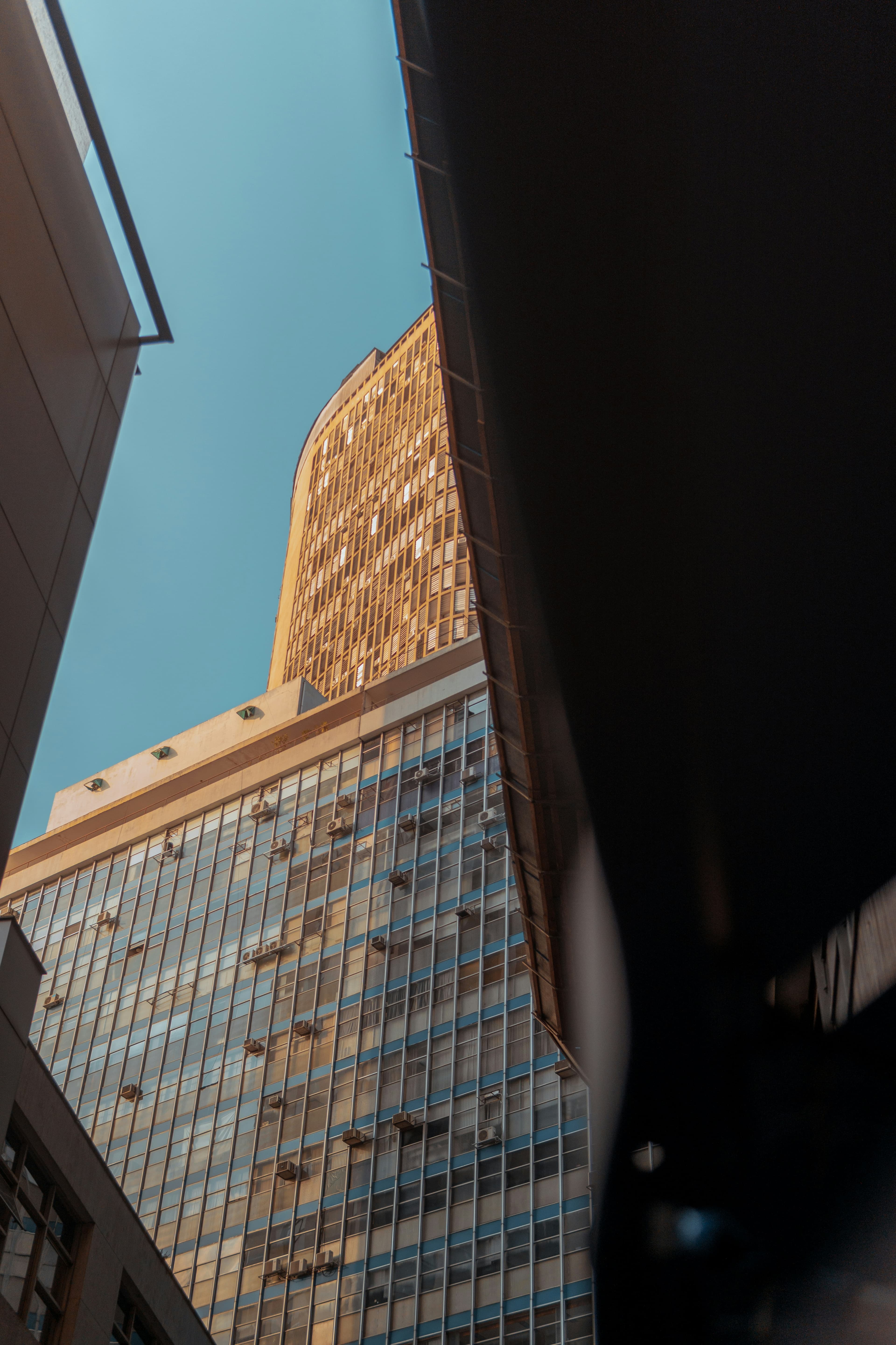 Warm golden glass building tower viewed from below